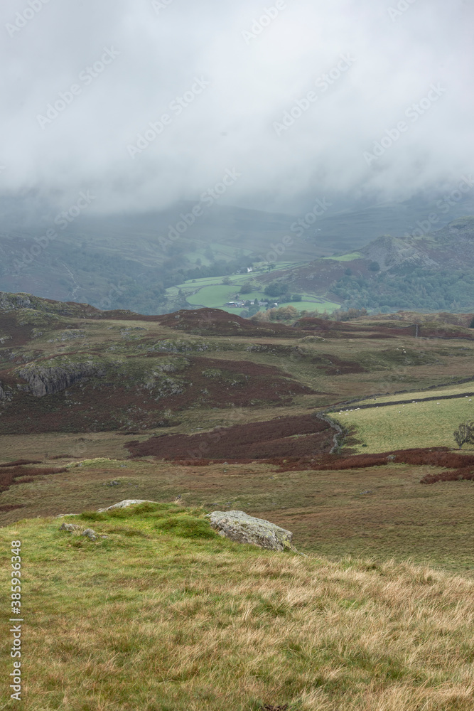 Fototapeta premium Low cloud hanging over Lake District landscape giving a dramatic image looking into the distant hills and mountains