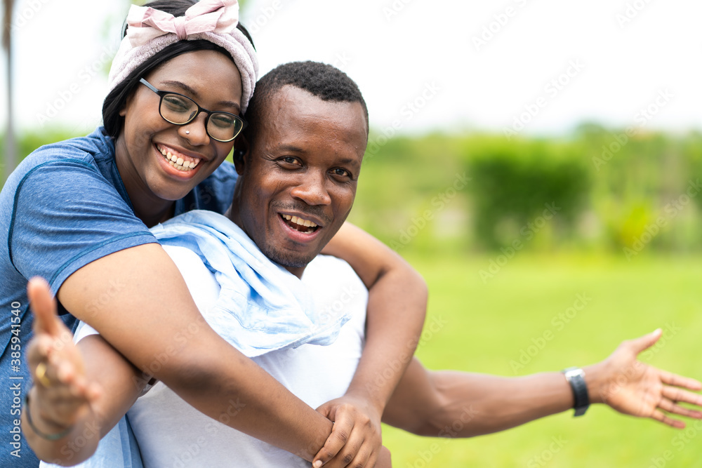 African American couple in love smiling and looking at camera outdoors at park African American couple in love smiling and looking at camera outdoors at park