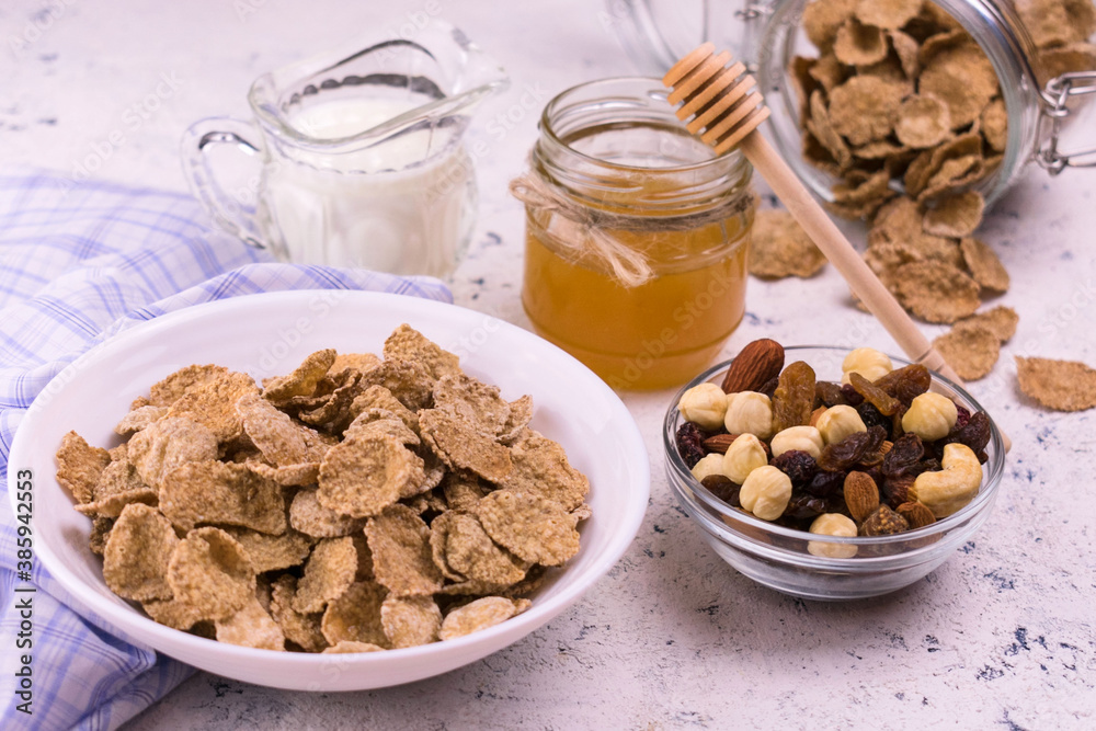 Whole grain breakfast cereal with honey and nuts on a white plate. Whole grain breakfast cereal with honey and nuts on a white plate.