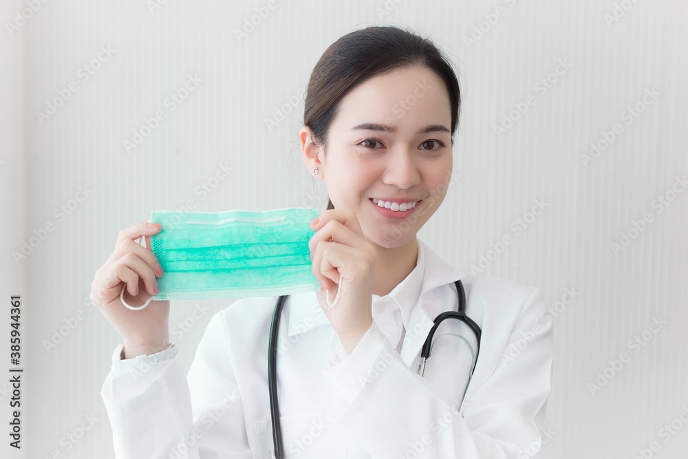 Asian woman hold a medical face mask to show that we have to wear its to protect respiration system from pollution and virus (Covid 19). Health and Corona virus concept. Asian woman hold a medical face mask to show that we have to wear its to protect respiration system from pollution and virus (Covid 19). Health and Corona virus concept.