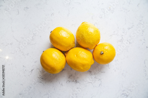 Group of lemon fruits on a marble background, top view.