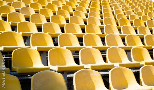 yellow tribunes. seats of tribune on sport stadium. empty outdoor arena. concept of fans. chairs for audience. cultural environment concept. color and symmetry. empty seats. modern stadium