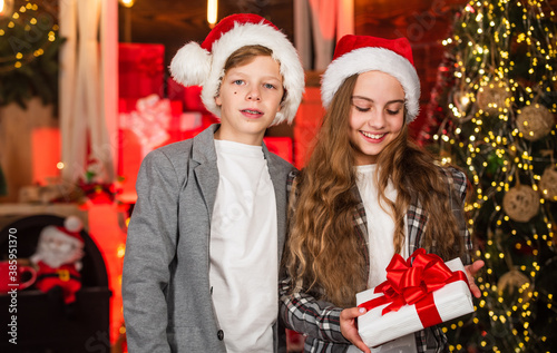 Kids lovely friends meet Christmas holiday. Sister and brother. Closest people. Family celebrate Christmas. Best friends forever. Festive atmosphere christmas day. Boy and girl santa claus hats