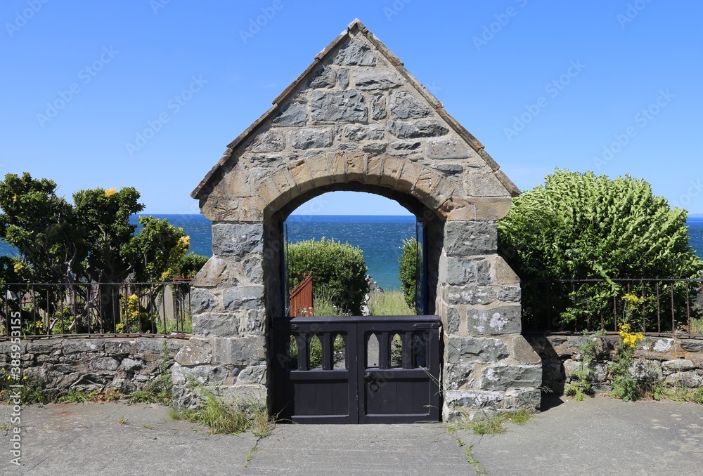 Obraz premium The lychgate to St. Mary and St. Bodfan's Church beside Cardigan Bay, at Llanaber, Wales, UK.