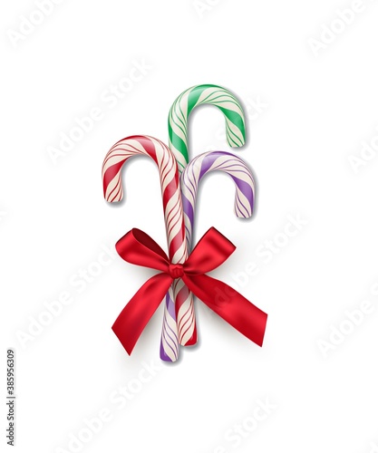 Three different color striped candy canes with red bow isolated on white background. Vector Christmas and New Year design element.