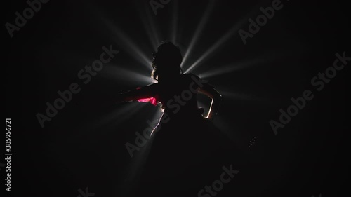 Bottom view of a silhouette of a woman performing flamenco dance elements in the spotlight. Slow motion.