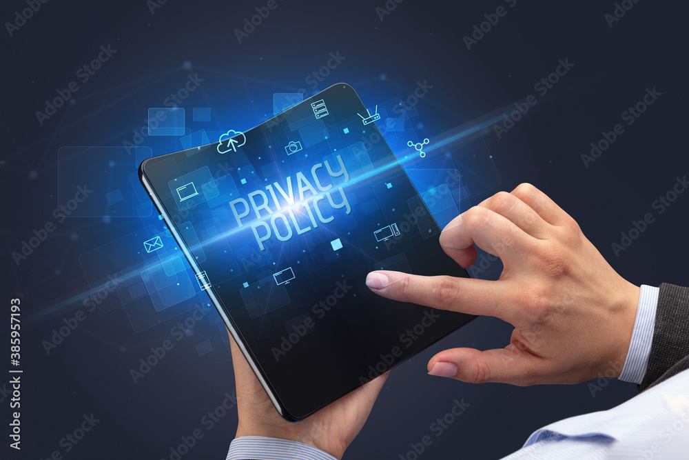 Businessman holding a foldable smartphone with PRIVACY POLICY inscription, cyber security concept Businessman holding a foldable smartphone with PRIVACY POLICY inscription, cyber security concept