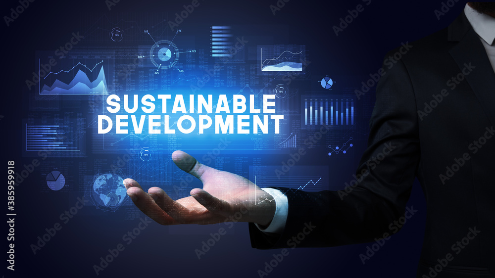 Hand of Businessman holding SUSTAINABLE DEVELOPMENT inscription, business success concept Hand of Businessman holding SUSTAINABLE DEVELOPMENT inscription, business success concept