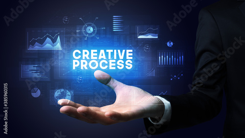 Hand of Businessman holding CREATIVE PROCESS inscription, business success concept