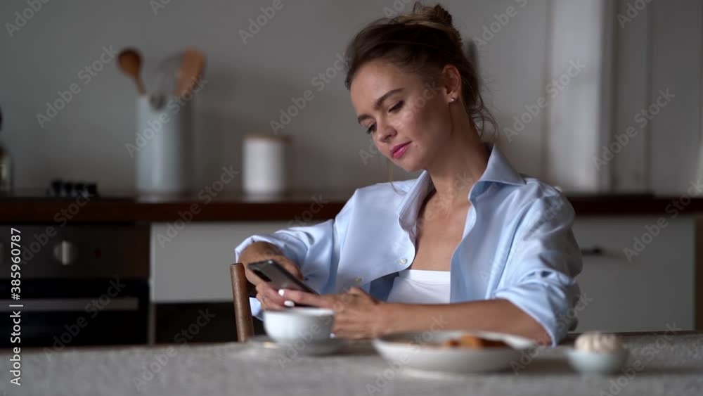 housewife is resting at home after housework, using smartphone, checking social nets