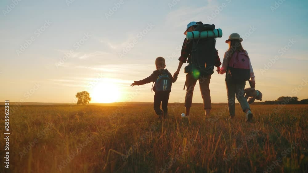 Silhouettes of mother with two kids hiking on nature on sunset. Concept of friendly family. Silhouettes of mother with two kids hiking on nature on sunset. Concept of friendly family.