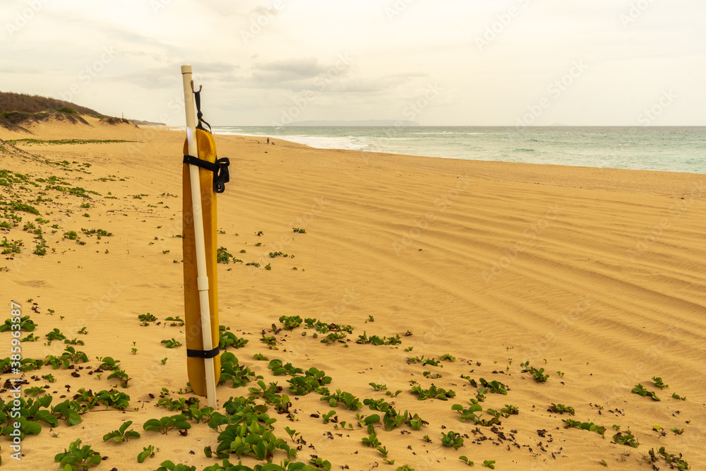Emergency flotation device for public use mounted on a pole made of plastic pipe in the sand on the beach, Polihale State Park, Kauai..