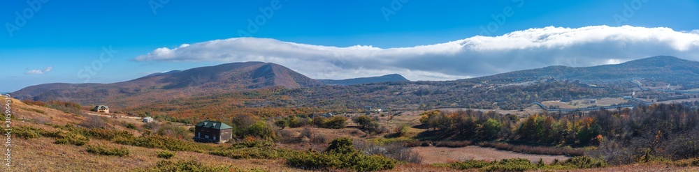 Panoramic view of the autumn mountain forests and the village