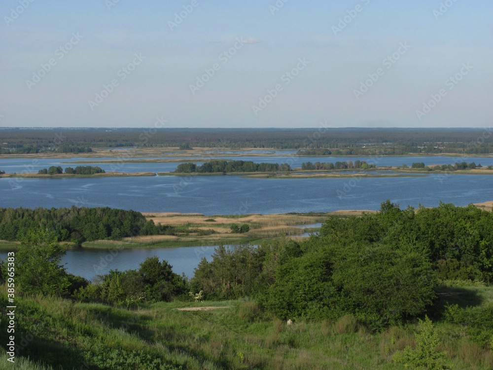landscape background: green forest, river with islands and blue sky
