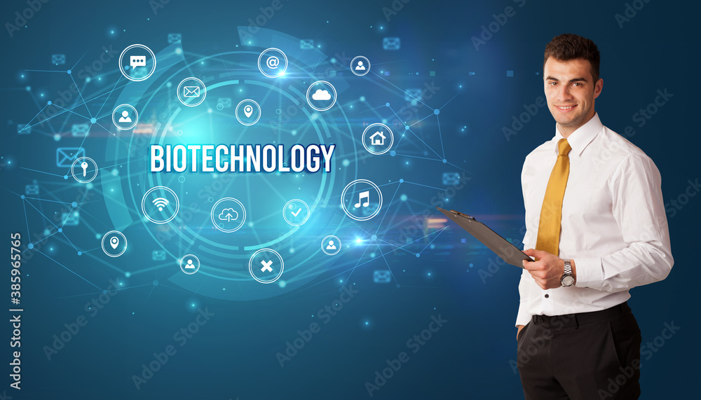 Businessman thinking in front of technology related icons and BIOTECHNOLOGY inscription, modern technology concept Businessman thinking in front of technology related icons and BIOTECHNOLOGY inscription, modern technology concept