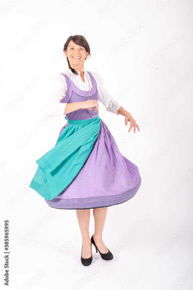 brunette woman wearing a bavarian dirndl and dancing on white background brunette woman wearing a bavarian dirndl and dancing on white background