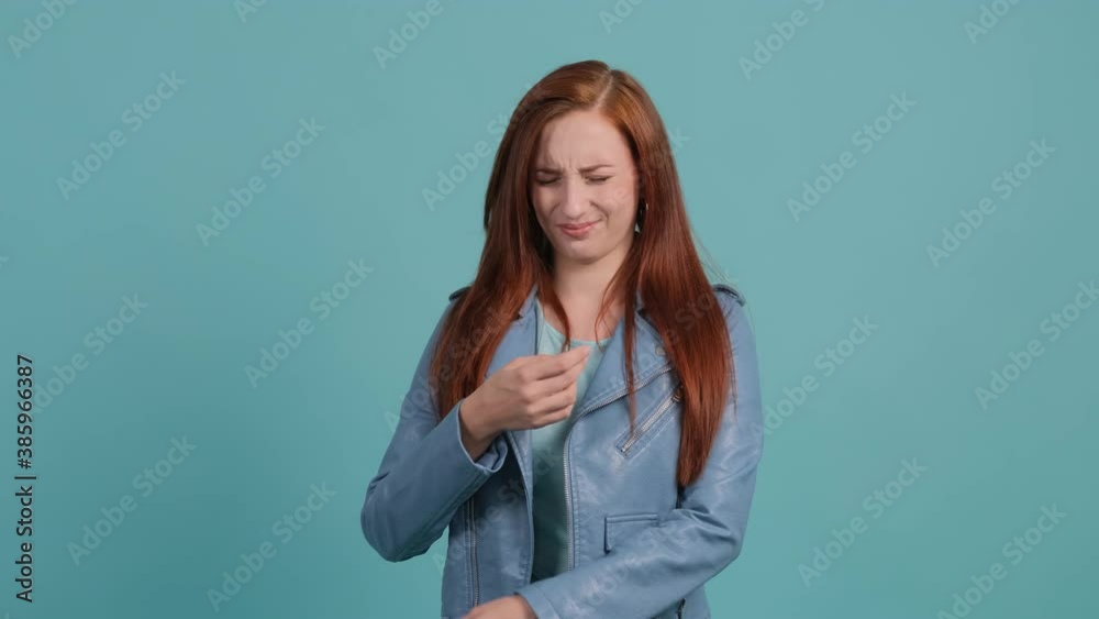 Close up of an young woman that is showing disgust, pinching her nose to avoid bad smell. Negative emotions, nasty feelings.