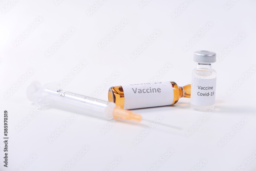 Close up of coronavirus vaccine and syringe on white background Close up of coronavirus vaccine and syringe on white background