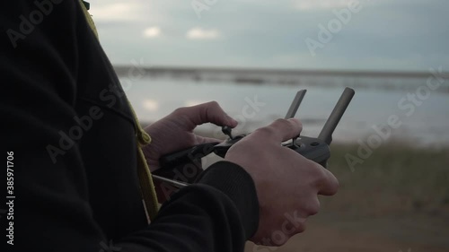 Drone remote controller. Pilot - operating quadcopter with remote controller and smartphone on sunset. Joysticks. Sticks close up. Close up hands with RC. 