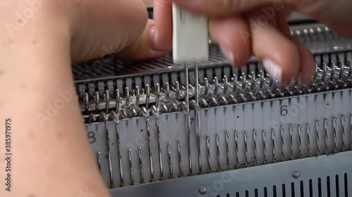 Female hands making textile on weaving machine at factory. Knitting machine Close up of weaving fabric on loom machine. Manufacturing knitted fabric on manual knitting equipment. Textile industry