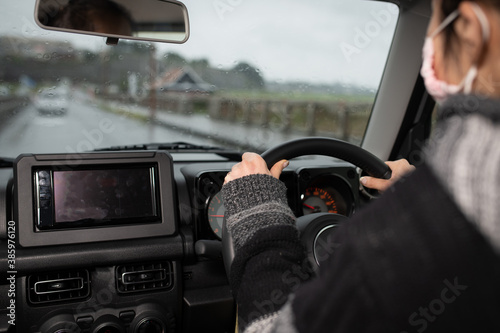 雨の日に自動車を運転する女性の手元