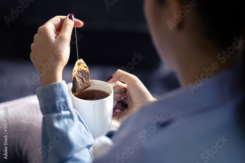 Photos Woman holding tea bag in cup to make a healthy hot beverage in winter