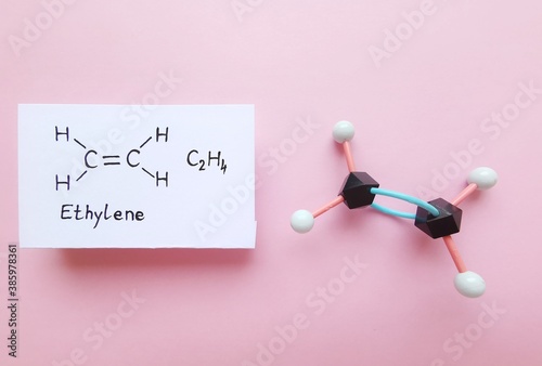 Ethylene (ethene) molecule. Molecular structure model and structural chemical formula of ethylene molecule. Used in production of polyethylene but also important as a plant hormone. Black=C, white=H. photo