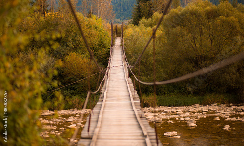 Landscape view of wooden suspension bridge over mountains river