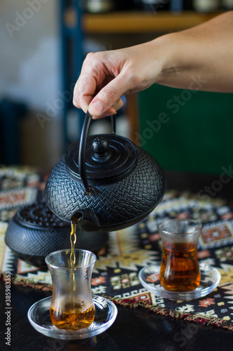 Black tea and teapot in hand, Turkish tea glasses