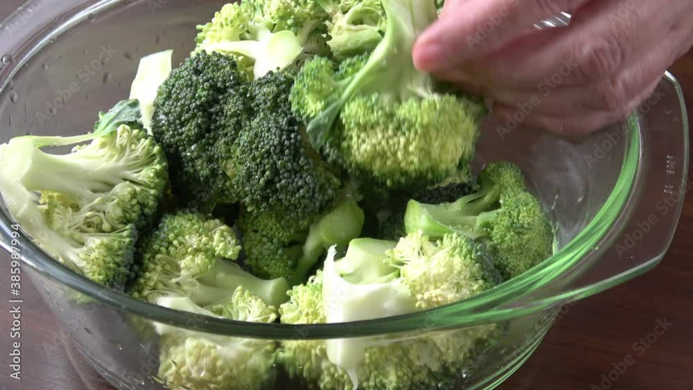 Woman hands cutting broccoli in the kitchen. Cooking vegan food.
Woman hands cutting broccoli in the kitchen. Cooking vegan food.