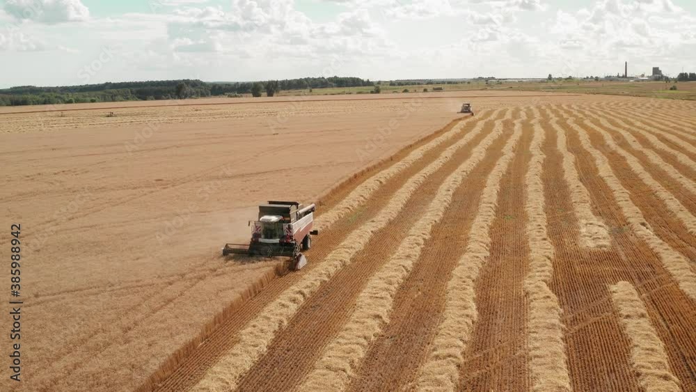 Combine harvester working on a wheat field. Seasonal harvesting the wheat. Agriculture. Combine harvester working on a wheat field. Seasonal harvesting the wheat. Agriculture.