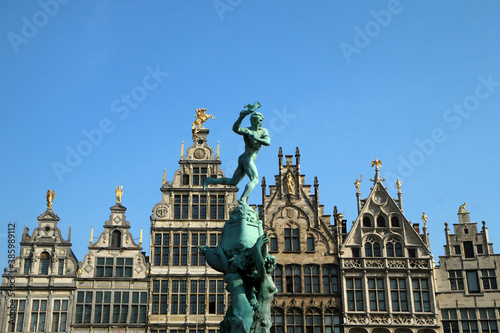 The detail of the old historic houses at the square in Belgian city of Antwerp. with a statue on the fountain in front of them.  © shootingtheworld