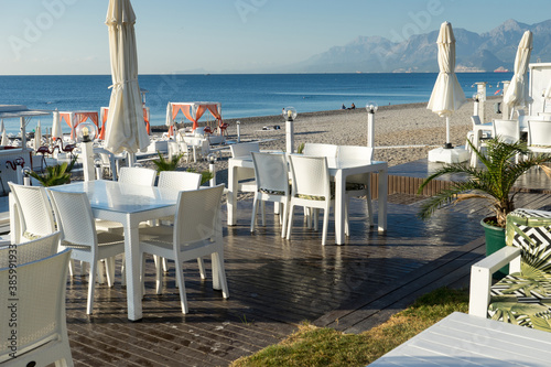 Famous Konyaaltı beach and the Mediterranean sea, white chairs and tables. Close-up photo, Antalya Turkey © Bulent
