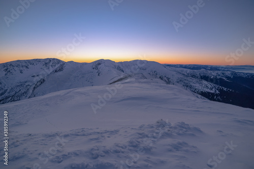 after sunset on a mountain ridge in the winter landscape