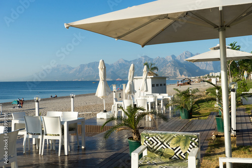 Famous Konyaaltı beach and the Mediterranean sea, white chairs and tables. Close-up photo, Antalya Turkey