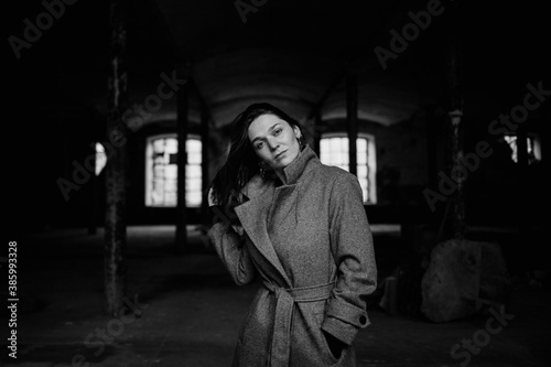 Moody black and white portrait of young caucasian woman in abandoned destroyed building. © Maria