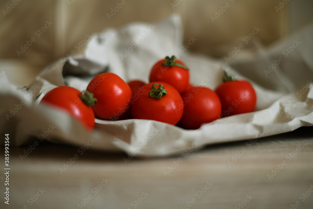 Raw ripe oraganic tomatoes on wooden kitchen table.