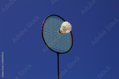 Raquete de badminton com peteca e fundo do céu azul