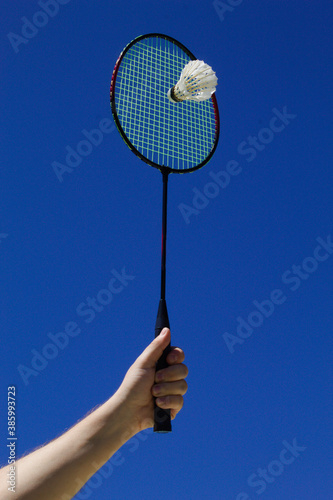 Raquete de badminton com peteca e fundo do céu azul