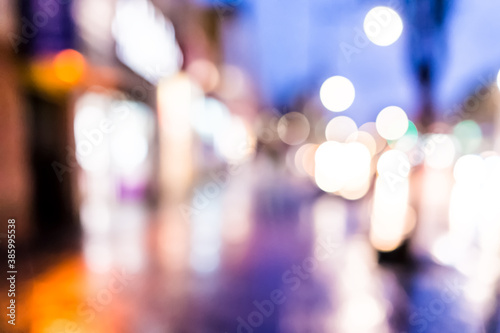 Abstract bokeh background of New York City Manhattan NYC Bronx Fordham heights street at twilight purple evening during rainy day with reflection of sidewalk  car lights