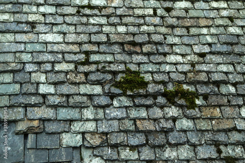 The detail of the old medieval slate roof on a very old house. 