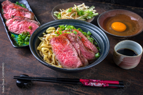 Modern style traditional Japanese ramen soup with wagyu beef filet and noodles as close-up in a design bowl