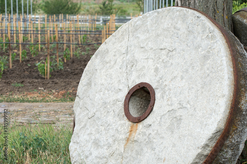 Vászonkép Old millstone for the mill. Large stone round millstone.