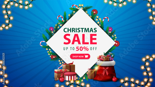 Christmas sale, discount banner with diamond-shaped frame of Christmas tree branches and garlands around offer, pink button and garland frame on blue background
