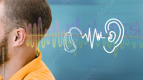 Advertising hearing solution. Hearing test, sound waves showing modern deafness diagnostic over male ear with BTE hearing aid photo
