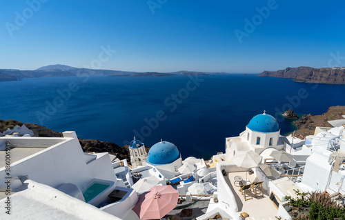Panoramic view of Oia town in Santorini island with old whitewashed houses and typical blue domes of orthodox churches, Greece. Greek landscape on a sunny day