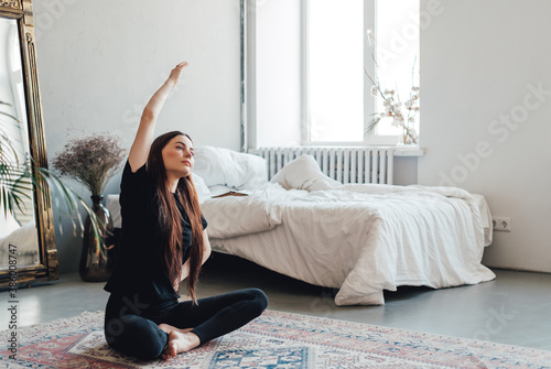 Beautiful brunette fitness woman make stretching exercises, doing yoga indoors at home. Staying fit and healthy photo