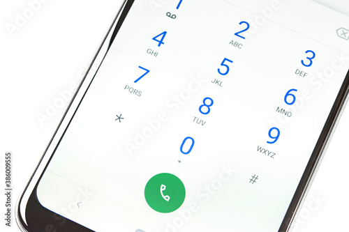 Billede på lærred Modern smartphone screen with numbers dialing keypad in close-up on a white back