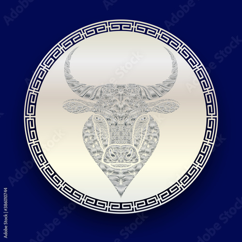 Silver patterned head of a bull on a white metal disk. Face of ox symbol of new 2021 year on a blue background. Template for envelope, banner, poster, greeting cards.