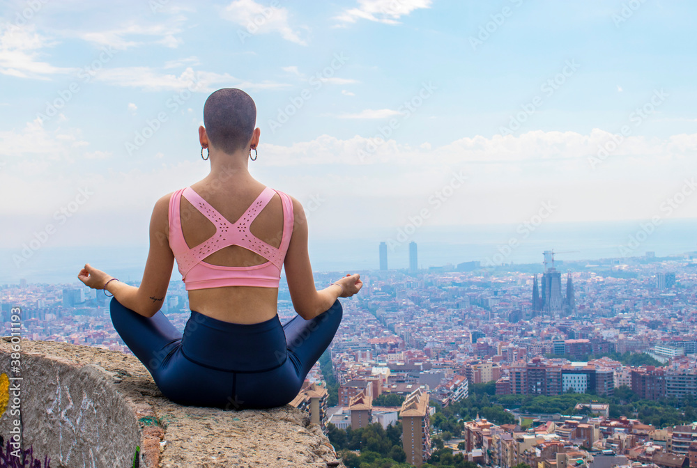 Mujer haciendo yoga al aire libre con la ciudad de fondo